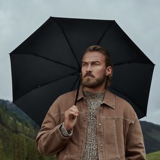 Mann hält einen Knirps Manual Regenschirm in Schwarz in der Hand