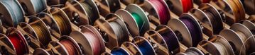 Bunte Spulen in verschiedenen Farben, ordentlich in einer Holzschachtel arrangiert