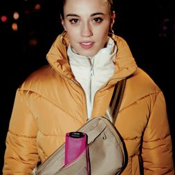 Knirps U.S.050 in Neonpink Knirps U.S.050 Regenschirm in Neonpink, verstaut in einer Umhängetasche bei einer Frau