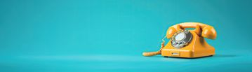 Gelbes Telefon auf türkisfarbenem Hintergrund